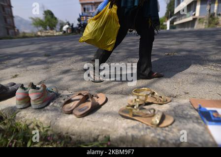 Un homme marche vers la maison dans des sandales à Dhulikhel, Kavrepalanchok, Népal vendredi, 10 avril 2020. Les habitants de Dhulikhel et les jeunes ont fourni gratuitement des chaussures et des aliments, y compris du riz battu (chiura), des collations sèches (dalmoth), des nouilles, des biscuits, des masques, Solution de réhydratation orale (SRO) et eau potable pour les personnes marchant vers leur maison à pied pendant le confinement imposé par le gouvernement pour minimiser les risques de Covid-19. Les locaux ont également géré des autobus et des camions, entre autres, pour transporter les gens qui veulent partir pour leurs maisons. Jusqu'à aujourd'hui, plus de centaines de personnes se sont démis vers leurs maisons tôt dans t Banque D'Images