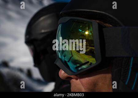 Deux skieurs sur les casques de télésiège et des lunettes sur la dame sur les lunettes réfléchissantes de levage Banque D'Images