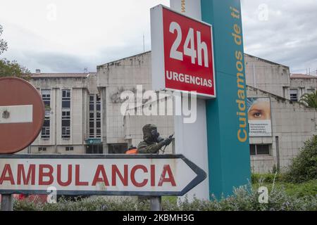 Un soldat désinfecte derrière un panneau à l'entrée de l'enceinte du Sanatorium de Covadonga, où vous pouvez lire ''ambulance''. ''24 heures d'urgence'' et ''nous nous occuper de vous''. Des troupes de l'armée espagnole ont effectué des travaux de désinfection au Sanatorium Covadonga, une résidence privée qui accueille plusieurs patients atteints de coronavirus, à Gijón, en Espagne, sur 17 avril 2020. Ces travaux font partie de l'« opération Balmis » lancée par le Gouvernement pour la collaboration des forces armées dans la lutte contre la pandémie du coronavirus. Dans ce cadre, plus de 90 000 soldats ont été mobilisés Banque D'Images