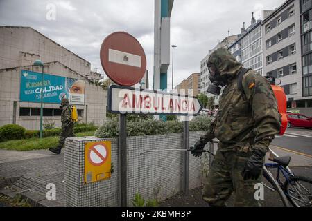 Un soldat désinfecte devant le panneau d'entrée d'une ambulance. Un soldat désinfecte devant un panneau du Sanatorium de Covadonga qui indique l'entrée des ambulances. Des troupes de l'armée espagnole ont effectué des travaux de désinfection au Sanatorium Covadonga, une résidence privée qui accueille plusieurs patients atteints de coronavirus, à Gijón, en Espagne, sur 17 avril 2020. Ces travaux font partie de l'« opération Balmis » lancée par le Gouvernement pour la collaboration des forces armées dans la lutte contre la pandémie du coronavirus. Dans ce cadre, plus de 90 000 soldats ont été mobilisés, Banque D'Images