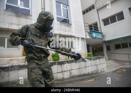 Un soldat désinfecte à l'entrée du Sanatorium de Covadonga. Des troupes de l'armée espagnole ont effectué des travaux de désinfection au Sanatorium Covadonga, une résidence privée qui accueille plusieurs patients atteints de coronavirus, à Gijón, en Espagne, sur 17 avril 2020. Ces travaux font partie de l'« opération Balmis » lancée par le Gouvernement pour la collaboration des forces armées dans la lutte contre la pandémie du coronavirus. Dans ce cadre, jusqu'à plus de 90 000 soldats ont été mobilisés, avec une moyenne de 550 interventions quotidiennes axées sur la désinfection des installations publiques et privées, healt Banque D'Images