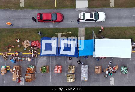 Dans cette vue aérienne, les bénévoles distribuent de la nourriture de la deuxième banque alimentaire de récolte du centre de la Floride aux familles dans le besoin lors d'un événement en voiture sur 17 avril 2020 à l'église de la Nouvelle Jérusalem à Kissimmee, en Floride. Les banques alimentaires des États-Unis connaissent une augmentation de la demande à mesure que le nombre de chômeurs augmente en raison des licenciements causés par la pandémie du coronavirus (COVID-19). (Photo de Paul Hennessy/NurPhoto) Banque D'Images