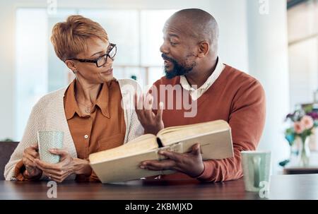 Couple lisant la bible, la foi à la maison et parlant de la religion avec le café pour l'apprentissage, l'étude et l'éducation. Homme noir, livre Saint en main et spirituel Banque D'Images