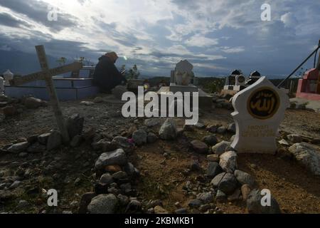 Un certain nombre de musulmans se souviennent et prient pour leurs familles qui sont mortes et sont enterrées dans les tombes massives des victimes du tremblement de terre, du tsunami et de la liquéfaction à Poboya TPU, Palu, province centrale de Sulawesi, Indonésie, sur 19 avril, 2020. Devant le Ramadan, la zone d'enfouissement de masse de milliers de victimes du tremblement de terre, du tsunami et de la liquéfaction qui a frappé la ville de Palu le 28 septembre 2018 était bondée de résidents qui sont venus prier pour leurs familles qui ont été victimes de la catastrophe. (Photo par Mohamad Hamzah/NurPhoto) Banque D'Images