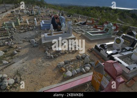 Un certain nombre de musulmans se souviennent et prient pour leurs familles qui sont mortes et sont enterrées dans les tombes massives des victimes du tremblement de terre, du tsunami et de la liquéfaction à Poboya TPU, Palu, province centrale de Sulawesi, Indonésie, sur 19 avril, 2020. Devant le Ramadan, la zone de sépulture de masse de milliers de victimes du tremblement de terre, du tsunami et de la liquéfaction qui a frappé la ville de Palu le 28 septembre 2018 était bondée de résidents venus prier pour leurs familles victimes de la catastrophe. (Photo par Mohamad Hamzah/NurPhoto) Banque D'Images