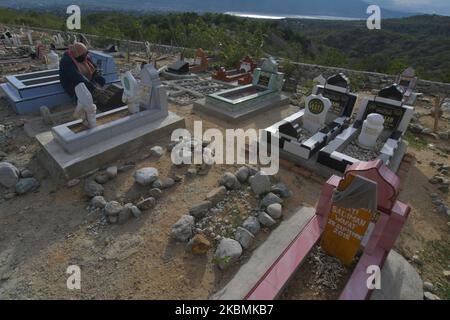 Un certain nombre de musulmans se souviennent et prient pour leurs familles qui sont mortes et sont enterrées dans les tombes massives des victimes du tremblement de terre, du tsunami et de la liquéfaction à Poboya TPU, Palu, province centrale de Sulawesi, Indonésie, sur 19 avril, 2020. Devant le Ramadan, la zone de sépulture de masse de milliers de victimes du tremblement de terre, du tsunami et de la liquéfaction qui a frappé la ville de Palu le 28 septembre 2018 était bondée de résidents venus prier pour leurs familles victimes de la catastrophe. (Photo par Mohamad Hamzah/NurPhoto) Banque D'Images