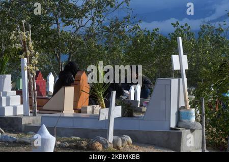 Un certain nombre de musulmans se souviennent et prient pour leurs familles qui sont mortes et sont enterrées dans les tombes massives des victimes du tremblement de terre, du tsunami et de la liquéfaction à Poboya TPU, Palu, province centrale de Sulawesi, Indonésie, sur 19 avril, 2020. Devant le Ramadan, la zone d'enfouissement de masse de milliers de victimes du tremblement de terre, du tsunami et de la liquéfaction qui a frappé la ville de Palu le 28 septembre 2018 était bondée de résidents qui sont venus prier pour leurs familles qui ont été victimes de la catastrophe. (Photo par Mohamad Hamzah/NurPhoto) Banque D'Images