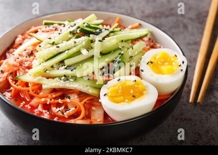Nouilles froides épicées coréennes Bibim Guksu closeup dans le bol sur la table. Horizontale Banque D'Images