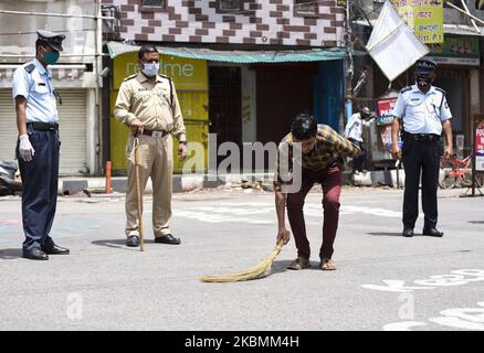 La police punit un homme pour avoir cracher dans un lieu public, lors de l'isolement national pour enrayer la propagation du coronavirus, à Guwahati, Assam, Inde lundi, 20 avril, 2020. (Photo de David Talukdar/NurPhoto) Banque D'Images