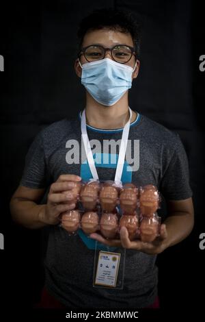 Un volontaire pose pour la photographie avec des paquets d'oeufs, l'un des articles d'un paquet alimentaire qui sera distribué aux familles à faible revenu à Yangon, au Myanmar pendant la pandémie du coronavirus COVID-19, sur 21 avril 2020. (Photo de Shwe Paw Mya Tin/NurPhoto) Banque D'Images