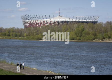 Les gens sont vus marcher le long du boulevard sur la Vistule avec le stade national en arrière-plan à Varsovie, Pologne sur 20 avril 2020. Alors que la Pologne a atteint dimanche son pic de nouvelles infections à COVID-19 depuis que la première victime a été enregistrée début mars, le gouvernement assouplit lentement les restrictions sur la vie publique permettant aux gens d'utiliser les parcs et les forêts. D'autres mesures d'assouplissement seront annoncées dans les semaines à venir, car le gouvernement est convaincu que le pic de l'épidémie sera atteint en avril ou début mai. Les mesures de quarantaine devraient entraîner une baisse de quatre à cinq pour cent du PIB et un Banque D'Images