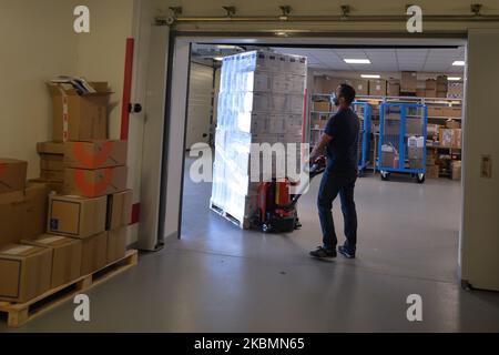 Le personnel de l'hôpital décharge une piste avec un équipement de protection individuelle et la place dans la salle de stockage de l'hôpital universitaire de Cracovie. Aujourd'hui, la première partie de l'EPI comprenant des milliers de robes chirurgicales, des gants, des masques, des casques et des combinaisons de matières dangereuses, achetés dans le cadre de 'Lesse Pologne province anti-crise Shield', a été livrée à l'hôpital universitaire. Deux autres camions d'une valeur de 3,5 millions de PLN (l'équivalent de 770 000 euros) sont attendus plus tard dans la semaine. Mardi, 21 avril 2020, à Cracovie, en Pologne. (Photo par Artur Widak/NurPhoto) Banque D'Images