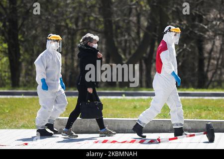 Un médecin portant un uniforme de protection accompagne un patient dans le service de maladies infectieuses de l'hôpital universitaire de Cracovie, en Pologne, sur 21 avril 2020. L'hôpital teste des échantillons pour le coronavirus à l'aide de la machine de démonstration Cobas 6800, très efficace, fournie par la société pharmaceutique Roche, qui peut réaliser jusqu'à 1 400 tests par jour. (Photo de Beata Zawrzel/NurPhoto) Banque D'Images
