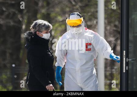 Un médecin portant un uniforme de protection accompagne un patient dans le service de maladies infectieuses de l'hôpital universitaire de Cracovie, en Pologne, sur 21 avril 2020. L'hôpital teste des échantillons pour le coronavirus à l'aide de la machine de démonstration Cobas 6800, très efficace, fournie par la société pharmaceutique Roche, qui peut réaliser jusqu'à 1 400 tests par jour. (Photo de Beata Zawrzel/NurPhoto) Banque D'Images