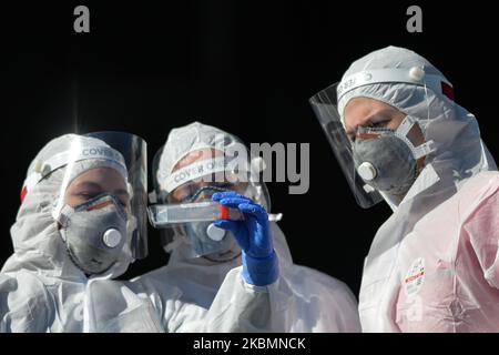 Diagnostics laboratoires médicaux les travailleurs vérifient un kit de test avant de procéder à un prélèvement d'échantillons pour le dépistage du coronavirus au centre de test au drive de Tauron Arena à Cracovie. La société privée facture 584 zloty polonais (environ 130 euros) pour le test. Le nombre d'infectés par le virus continue de croître en Pologne et le ministère de la Santé a signalé aujourd'hui 263 nouveaux cas et 21 décès, avant 5pm, ce qui porte le nombre total à 9 865 personnes infectées, 401 décès et 1 297 cas de rétablissement. Mardi, 21 avril 2020, à Cracovie, en Pologne. (Photo par Artur Widak/NurPhoto) Banque D'Images