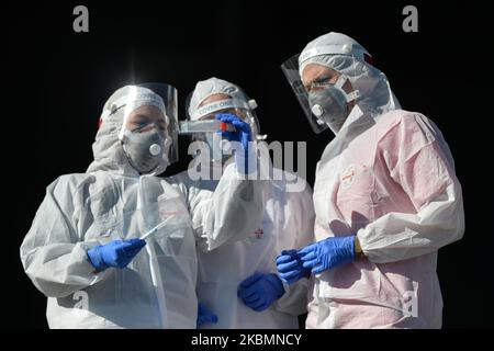 Diagnostics laboratoires médicaux les travailleurs vérifient un kit de test avant de procéder à un prélèvement d'échantillons pour le dépistage du coronavirus au centre de test au drive de Tauron Arena à Cracovie. La société privée facture 584 zloty polonais (environ 130 euros) pour le test. Le nombre d'infectés par le virus continue de croître en Pologne et le ministère de la Santé a signalé aujourd'hui 263 nouveaux cas et 21 décès, avant 5pm, ce qui porte le nombre total à 9 865 personnes infectées, 401 décès et 1 297 cas de rétablissement. Mardi, 21 avril 2020, à Cracovie, en Pologne. (Photo par Artur Widak/NurPhoto) Banque D'Images