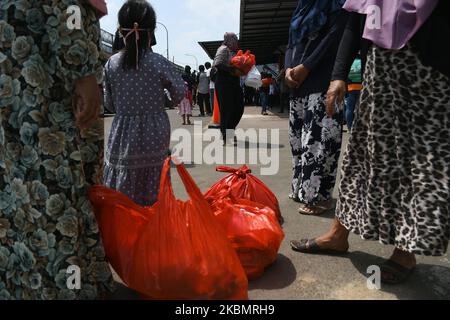 Les résidents reçoivent des sacs d'épicerie pendant la pandémie Covid-19 à la prison de Cipinang à Jakarta, on 23 avril,2020. Des centaines de gardiens ont donné des articles d'épicerie aux pauvres de la zone située à l'extérieur du complexe de logement du centre de détention. (Photo de Dasril Roszandi/NurPhoto) Banque D'Images