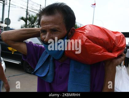 Les résidents reçoivent des sacs d'épicerie pendant la pandémie Covid-19 à la prison de Cipinang à Jakarta, on 23 avril,2020. Des centaines de gardiens ont donné des articles d'épicerie aux pauvres de la zone située à l'extérieur du complexe de logement du centre de détention. (Photo de Dasril Roszandi/NurPhoto) Banque D'Images