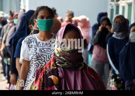 Les résidents reçoivent des sacs d'épicerie pendant la pandémie Covid-19 à la prison de Cipinang à Jakarta, on 23 avril,2020. Des centaines de gardiens ont donné des articles d'épicerie aux pauvres de la zone située à l'extérieur du complexe de logement du centre de détention. (Photo de Dasril Roszandi/NurPhoto) Banque D'Images