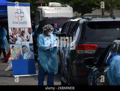 23 avril 2020 - Sanford, Floride, États-Unis - les travailleurs de la santé accueillent les gens qui arrivent en voiture sur un site mobile d'essai de la COVID-19 au centre communautaire de Westside, dans le quartier de Goldsboro de Sanford, en Floride, sur 23 avril 2020. Les autorités sanitaires locales offrent des tests gratuits dans six communautés noires historiques du comté de Seminole pour aider les résidents qui ne sont pas seulement particulièrement vulnérables au coronavirus, mais qui ne peuvent pas se rendre à une clinique de santé ou qui pourraient être incapables de se payer une assurance maladie. (Photo de Paul Hennessy/NurPhoto) Banque D'Images