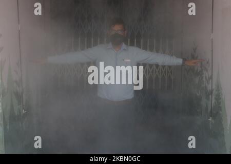 Un homme portant un masque de protection traverse un tunnel de désinfection installé dans une zone de marché pendant le confinement afin d'empêcher la propagation du nouveau coronavirus à Kolkata, en Inde, lundi, au 27 avril 2020. Les restrictions d'un mois dans ce pays de 1,3 milliards de personnes ont été quelque peu assouplies en permettant aux magasins de quartier de rouvrir et aux activités de fabrication et d'agriculture de reprendre dans les zones rurales pour aider des millions de pauvres salariés quotidiens. (Photo de Debajyoti Chakraborty/NurPhoto) Banque D'Images