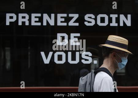 Un homme marche sur le front un panneau qui dit prendre soin de vous à Paris, comme un verrouillage est imposé pour ralentir le taux de la maladie du coronavirus (COVID-19) en France, 27 avril 2020. (Photo de Mehdi Taamallah/NurPhoto) Banque D'Images