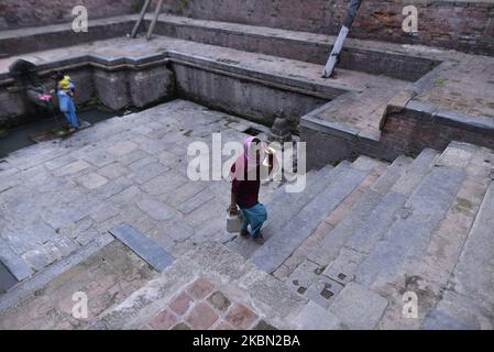 Une femme transportant de l'eau potable à partir de jets d'eau de pierre pendant le confinement comme inquiétude au sujet de la propagation du virus Corona (COVID-19) à Bhaktapur, Népal mercredi, 29 avril 2020. (Photo de Narayan Maharajan/NurPhoto) Banque D'Images