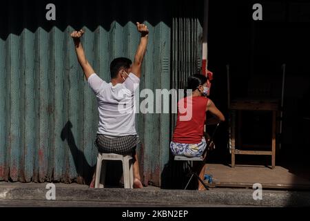 Un couple expose son dos à la lumière du soleil à San José, ville d'Antipolo, Philippines, sur 28 avril 2020. Selon les études, la lumière du soleil peut stimuler la vitamine D du corps, qui est bonne pour les poumons. Et d'autres chercheurs disent que le virus Covid-19 ne peut pas survivre plus longtemps lorsqu'il est exposé à la lumière directe du soleil. (Photo par Ryan Eduard Benaid/NurPhoto) Banque D'Images