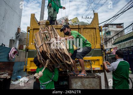 Les collecteurs d'ordures chargent le camion-citerne avec les déchets ménagers d'un quartier de Quezon City, Philippines, sur 29 avril 2020. Également salués comme des frontaux, les collecteurs d'ordures continuent à travailler en contact étroit avec différents déchets malgré les risques pour la santé et le manque d'équipement de protection individuelle (EPI). À ce jour, les Philippines ont enregistré un total de 8 212 cas de COVID-19, 558 décès et 1 023 reprises (photo de Lisa Marie David/NurPhoto). Banque D'Images