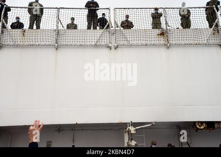 Des membres du département de police de New York et des marins de la marine américaine se font la vague les uns vers les autres comme la petite bande de tuyaux et de tambours du département de police de New York, debout au-dessus d'un parking vide à Pier90, Jouez et saluez le navire-hôpital USNS Comfort qui part de New York pendant l'épidémie du coronavirus, le jeudi 30 avril 2020. (Photo par B.A. Van Sise/NurPhoto) Banque D'Images