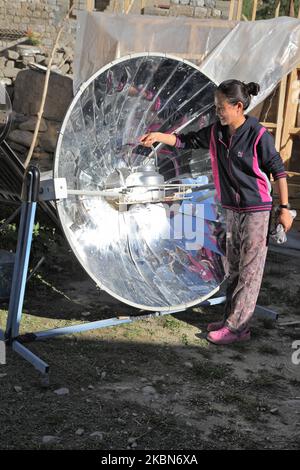 Ladakhi fille utilise une cuisinière solaire parabolique pour chauffer l'eau pour le thé à l'extérieur de sa maison dans le petit village de Tangtse, Ladakh, Jammu et Cachemire, Inde. (Cette image comporte une autorisation de modèle signée disponible) (photo de Creative Touch Imaging Ltd./NurPhoto) Banque D'Images