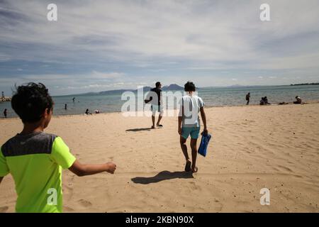 Un père et ses fils adolescents marchent sur le sable de la plage pour leur toute première baignade de l'année dans la ville côtière de Sidi Bou a dit, situé à environ 20 kilomètres au nord-est de la capitale Tunis, Alors qu'ils brassent le verrouillage général qui a été imposé par les autorités pour tenter de ralentir la propagation du nouveau coronavirus, qui cause la maladie de Covid-19. Le gouvernement tunisien a livré son plan de déconditionnement progressif qui prend effet en deux jours, en Tunisie, sur 02 mai 2020. (Photo de Chedly Ben Ibrahim/NurPhoto) Banque D'Images