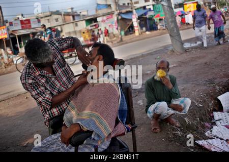 Un barbier travaille dans un saloon sur le bord de la route lors d'un confinement imposé par le gouvernement dans le cadre d'une épidémie de virus corona à Dhaka, au Bangladesh, le dimanche mai. 03, 2020. (Photo de Syed Mahamudur Rahman/NurPhoto) Banque D'Images