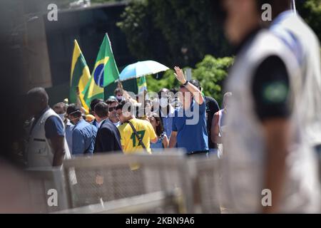 Le président brésilien Jair Bolsonaro assiste à ses partisans lors d'une manifestation en faveur du gouvernement et contre le blocage dans le cadre de l'épidémie du coronavirus (COVID-19) devant le palais de Planalto à Brasilia, Brésil, dimanche, 3 mai 2020. Des manifestants ont demandé une intervention militaire contre la Cour suprême fédérale du Brésil et le Congrès national. Sans masque, Bolsonaro a fait un geste en faveur des manifestants qui se bousculaient devant le bâtiment. Le président est venu près de la grille et a permis aux participants de l'acte d'entrer, qui a augmenté la rampe et a prolongé un drapeau brésilien. ( Banque D'Images