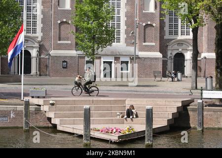 Les résidents locaux et les fleurs placées sont vus à l'Homomonument pendant le jour du souvenir pour célébrer 75 ans des victimes de la guerre dans le cadre de l'épidémie de coronavirus à 4 mai 2020 à Amsterdam, pays-Bas. Le jour du souvenir commémore les civils et les soldats hollandais qui sont morts dans des guerres ou des missions de maintien de la paix depuis le début de la Seconde Guerre mondiale. (Photo de Paulo Amorim/NurPhoto) Banque D'Images