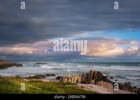 Magnifique scène côtière à Skulpiesbaai, Hermanus sur la côte des baleines, Overberg, Western Cape, Afrique du Sud, avec des rochers escarpés et des mers sauvages. Banque D'Images