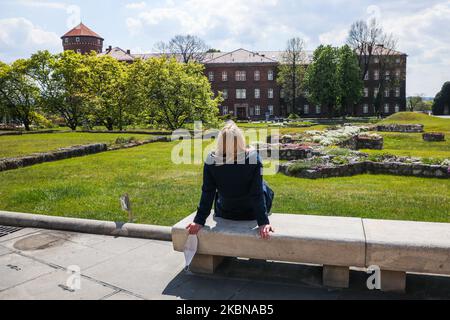 Une femme se détend avec son masque facial en train d'être retiré lors de sa visite à Wawel Hill, qui a été rouverte après avoir été fermée en mars en raison de la propagation du coronavirus. Cracovie, Pologne sur 4 mai 2020. Dans la première étape de la réouverture du château royal de Wawel, les visiteurs sont les bienvenus dans les espaces extérieurs - la cour à arcades, la cour extérieure et les jardins royaux. (Photo de Beata Zawrzel/NurPhoto) Banque D'Images