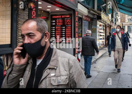 Le 5 mai 2020, les résidents d'Istanbul, le centre de la pandémie de Covid-19 en Turquie, portaient des masques lorsqu'ils magasinaient dans le quartier historique d'Eminonu, où de nombreux magasins restent fermés en raison des restrictions imposées pour enrayer la propagation du coronavirus. De telles précautions pèsent lourdement sur l'économie turque et sur la lire turque, qui est tombée à sa plus faible valeur depuis la crise financière de cette semaine. Au-dessus, des hommes turcs marchent près d'un magasin de change dans le quartier Eminonu de Fatih, Istanbul. (Photo de Diego Cupolo/NurPhoto) Banque D'Images