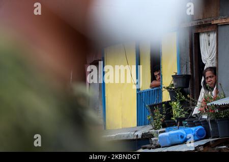 Les résidents regardent par leurs fenêtres les membres de l’armée de l’air des Philippines patrouillent dans une communauté placée « à l’isolement total » de la ville de Mandaluyong, à l’est de Manille, aux Philippines, sur 7 mai 2020. La zone a été mise en isolement total de 7 mai à 13 mai pour freiner la propagation de COVID19 dans la zone considérée comme une zone rouge par le gouvernement local. Les Philippines ont récemment enregistré 10 004 cas confirmés de COVID19, et ont atteint un total de 658 victimes dues à la maladie. (Photo de George Calvelo/NurPhoto) Banque D'Images