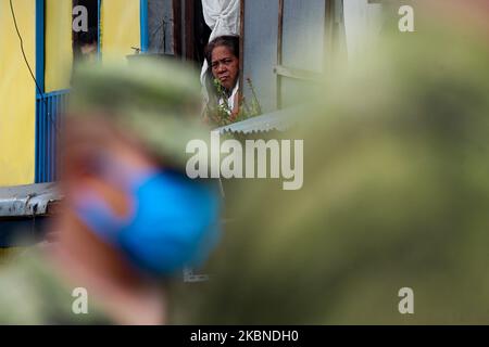 Les résidents regardent par leurs fenêtres les membres de l’armée de l’air des Philippines patrouillent dans une communauté placée « à l’isolement total » de la ville de Mandaluyong, à l’est de Manille, aux Philippines, sur 7 mai 2020. La zone a été mise en isolement total de 7 mai à 13 mai pour freiner la propagation de COVID19 dans la zone considérée comme une zone rouge par le gouvernement local. Les Philippines ont récemment enregistré 10 004 cas confirmés de COVID19, et ont atteint un total de 658 victimes dues à la maladie. (Photo de George Calvelo/NurPhoto) Banque D'Images