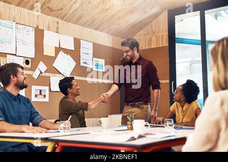 J'ai hâte de produire un travail impressionnant ensemble. Des hommes d'affaires se serrant la main pendant une réunion dans un bureau. Banque D'Images