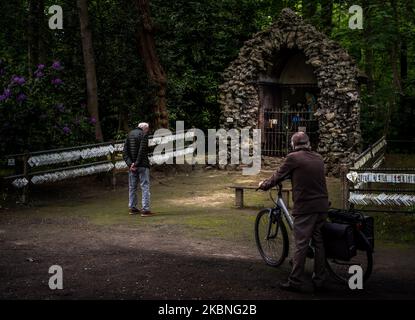 Un croyant aîné prie devant la grotte de Lourdes à Oostakker - Belgique le 08 mai 2020. Normalement, en mai, il est très occupé dans et autour de la cité de pèlerinage, en l'honneur de notre Dame de Lourdes réputée avoir des propriétés de guérison. Par la crise de la couronne (COVID19) aucun événement n'a lieu en raison d'un verrouillage strict à travers la Belgique pour arrêter la propagation de la pandémie de COVID-19, causée par le nouveau coronavirus. Les croyants sont autorisés à se promener et à prier et à allumer une bougie dans la basilique. Une grotte de Lourdes est une réplique de la grotte originale de Lourdes en France. (Photo de Jonathan Raa/NurPhoto) Banque D'Images