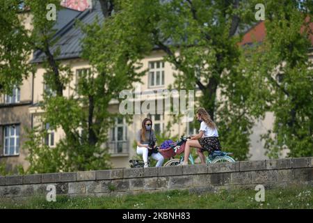 Deux jeunes femmes portant un masque de protection bavardes près du château de Wawel à Cracovie. Depuis lundi 4 mai, la deuxième étape du dégivrage de l'économie polonaise et du relâchement des restrictions a eu lieu. Les principaux changements concernent l'ouverture d'hôtels et autres logements, centres commerciaux (1 clients/15m2), institutions culturelles, bibliothèques, galeries d'art, musées, et centres de réadaptation, à l'exclusion des salons de massage. Samedi, 5 mai 2020, à Cracovie, en Pologne. (Photo par Artur Widak/NurPhoto) Banque D'Images