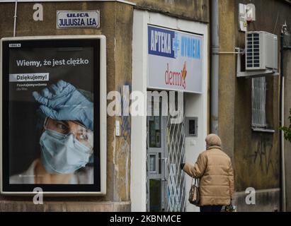 Une femme marche à côté d'une affiche « Merci aux professionnels de la santé » dans le centre de Cracovie, vue à l'occasion de la Journée internationale des infirmières. Mardi, 12 mai 2020, à Cracovie, en Pologne. (Photo par Artur Widak/NurPhoto) Banque D'Images