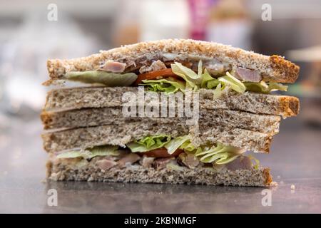 Comptoir déli frais dans un hypermarché de Cora. Employé préparant un sandwich avec du pain coupé en tranches Banque D'Images