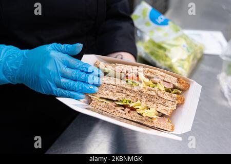 Comptoir déli frais dans un hypermarché de Cora. Employé préparant un sandwich avec du pain coupé en tranches Banque D'Images