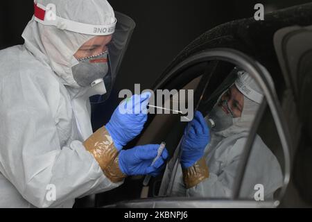 Diagnostic Medical Laboratories un employé effectue un écouvillon pour recueillir un échantillon pour le test du coronavirus au centre de test de la voie de passage de Tauron Arena à Cracovie. Depuis 18 mai, la troisième étape de dégel de l'économie et de relâchement des restrictions aura lieu et comprendra l'ouverture de salons de beauté, de restaurants, de bars et de cafés. Après le record d'hier de 595 nouveaux cas, le ministère de la Santé a signalé aujourd'hui 283 nouveaux cas et 22 décès, ce qui porte le nombre total à 17 204 personnes infectées, 861 décès et 6 410 ont récupéré. Mercredi, 13 mai 2020, à Cracovie, en Pologne. (Photo par Artur Widak/NurPhoto) Banque D'Images