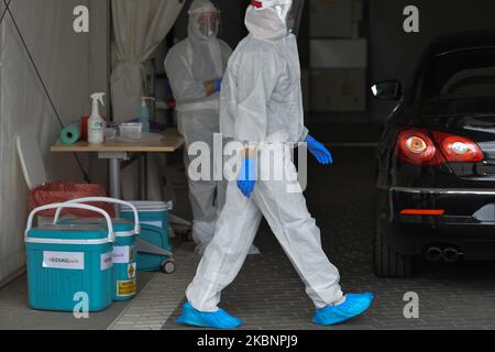 Les travailleurs des laboratoires médicaux de diagnostic se préparent à prélever un échantillon pour le test du coronavirus au centre de test de la voie de passage de Tauron Arena à Cracovie. Depuis 18 mai, la troisième étape de dégel de l'économie et de relâchement des restrictions aura lieu et comprendra l'ouverture de salons de beauté, de restaurants, de bars et de cafés. Après le record d'hier de 595 nouveaux cas, le ministère de la Santé a signalé aujourd'hui 283 nouveaux cas et 22 décès, ce qui porte le nombre total à 17 204 personnes infectées, 861 décès et 6 410 ont récupéré. Mercredi, 13 mai 2020, à Cracovie, en Pologne. (Photo par Artur Widak/N. Banque D'Images