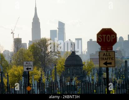 Des pierres tombales sont vues dans un cimetière de New York sur fond de gratte-ciel à Manhattan, aux États-Unis sur 13 mai 2020. (Photo de Selcuk Acar/NurPhoto) Banque D'Images