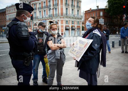 Une femme protestant discute avec un policier à Toulouse, en France, sur 16 mai 2020. Elle a été rapidement arrêtée et condamnée à une amende de 135EUR pour « rassemblement illégal ». Alors que le confinement en France s'est terminé sur 11 mai, les manifestants du Vest jaune ont appelé à une nouvelle manifestation pour 16 mai. Le rassemblement des Vêtes jaunes a été interdit par le préfet de haute-Garonne. Yellow Vêtes a tenté de se rassembler mais une présence policière lourde, des contrôles d'identité, des arrestations et des amendes les ont bloqués. La police a également envoyé un canon à eau. Presque tout le monde porte un masque protecteur alors que la pandémie DU coronavirus SRAS-COV-2 se poursuit. (Photo d'Alain Pitton/ Banque D'Images